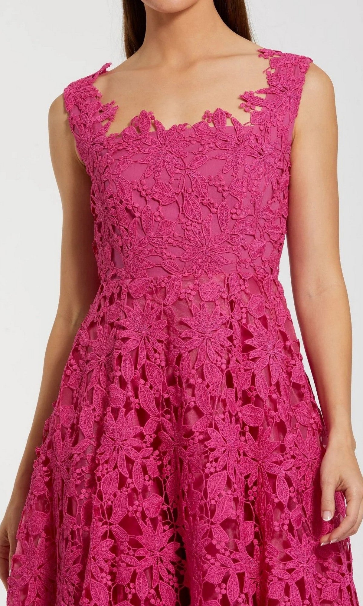 A woman wearing the Midi Party Dress: Mac Duggal 69073—this sleeveless, bright pink dress features intricate floral lace patterns, a fitted bodice, and an elegant A-line midi silhouette.